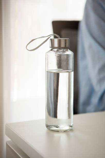 Botella de agua sobre una mesa con luz natural